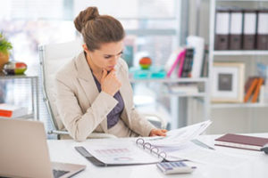 Thoughtful business woman documents in office